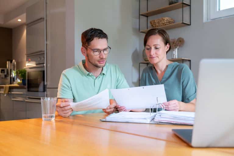 man vrouw aan tafel documenten doornemen